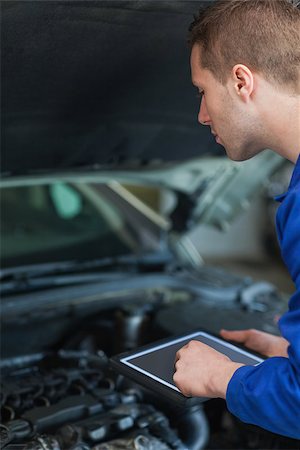 Male mechanic using digital tablet while examining car engine Stock Photo - Budget Royalty-Free & Subscription, Code: 400-06870199