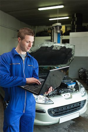 Male mechanic using laptop in auto repair shop Stock Photo - Budget Royalty-Free & Subscription, Code: 400-06870221
