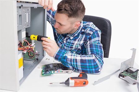 Young computer engineer working on cpu over white background Stock Photo - Budget Royalty-Free & Subscription, Code: 400-06870232