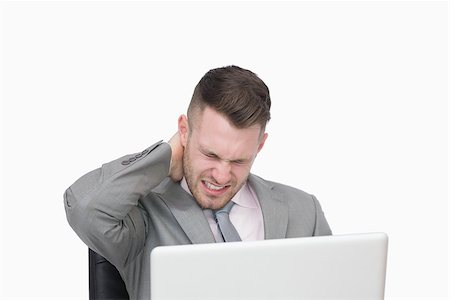 Business man suffering from severe neck pain while using laptop over white background Stock Photo - Budget Royalty-Free & Subscription, Code: 400-06870368