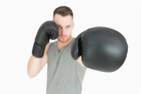 simsearch:400-06876600,k - Portrait of young male boxer punching over white background Stock Photo - Budget Royalty-Free & Subscription, Code: 400-06870455