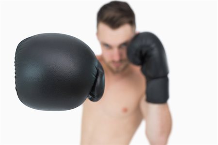simsearch:400-06876600,k - Portrait of young male boxer punching over white background Stock Photo - Budget Royalty-Free & Subscription, Code: 400-06870461