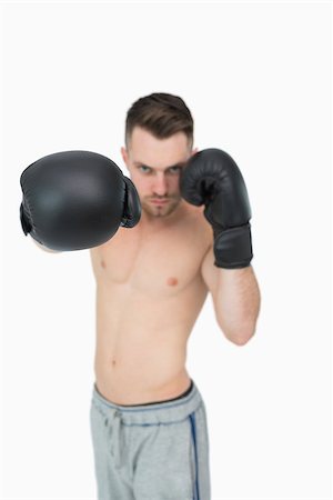 simsearch:400-06876600,k - Portrait of young male boxer punching over white background Stock Photo - Budget Royalty-Free & Subscription, Code: 400-06870462