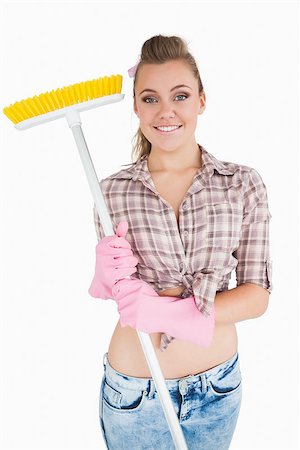 simsearch:400-06870646,k - Portrait of casual young woman holding broom over white background Stock Photo - Budget Royalty-Free & Subscription, Code: 400-06870609