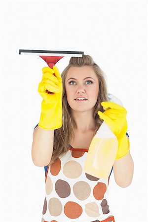 detergente - Beautiful young maid in yellow gloves using wiper and disinfectant spray over white background Foto de stock - Super Valor sin royalties y Suscripción, Código: 400-06870600
