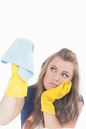 simsearch:400-06870642,k - Bored young maid in yellow gloves using duster over white background Stock Photo - Budget Royalty-Free & Subscription, Code: 400-06870603