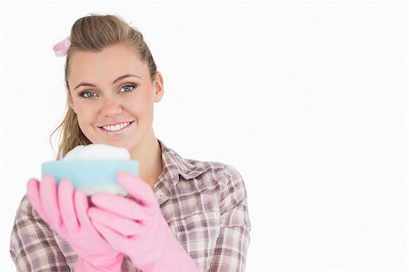 simsearch:400-06870642,k - Portrait of smiling young woman holding sponge over white background Stock Photo - Budget Royalty-Free & Subscription, Code: 400-06870617