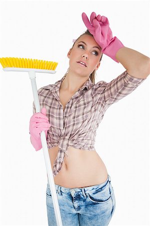 simsearch:400-06870646,k - Tired young woman holding broom over white background Stock Photo - Budget Royalty-Free & Subscription, Code: 400-06870610
