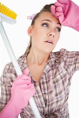 simsearch:400-06870646,k - Tired young woman holding broom over white background Stock Photo - Budget Royalty-Free & Subscription, Code: 400-06870611