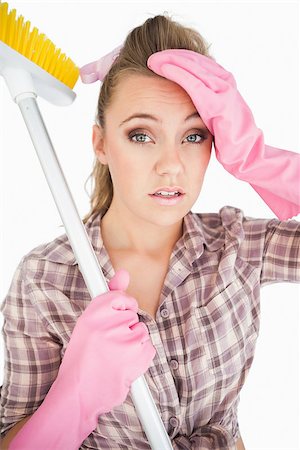 simsearch:400-06870646,k - Portrait of tired young woman holding broom over white background Stock Photo - Budget Royalty-Free & Subscription, Code: 400-06870612