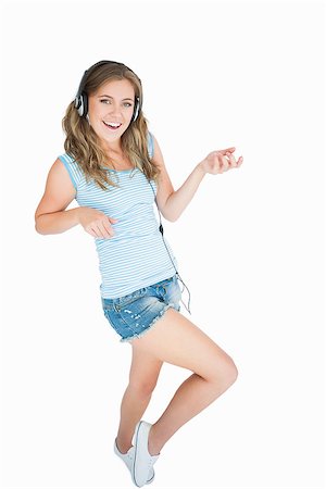 simsearch:400-06690896,k - Portrait of woman enjoying music over headphones and playing air guitar against white background Stock Photo - Budget Royalty-Free & Subscription, Code: 400-06870664