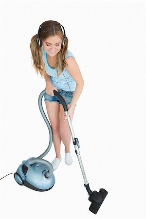 Young woman listening music over headphones while vacuuming against white background Stock Photo - Budget Royalty-Free & Subscription, Code: 400-06870677