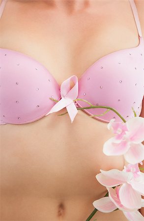 simsearch:400-06870717,k - Closeup of woman with breast cancer awareness ribbon attached to bra and flower Stock Photo - Budget Royalty-Free & Subscription, Code: 400-06870716