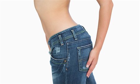 simsearch:400-04325983,k - Side midsection of slim woman in jeans standing over white background Stock Photo - Budget Royalty-Free & Subscription, Code: 400-06870800