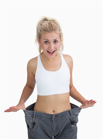 Young thin woman wearing old pants after losing weight over white background Stock Photo - Budget Royalty-Free & Subscription, Code: 400-06870810