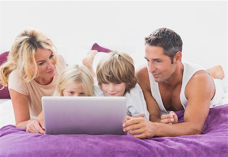 Family using together a laptop on a bed Stock Photo - Budget Royalty-Free & Subscription, Code: 400-06871497