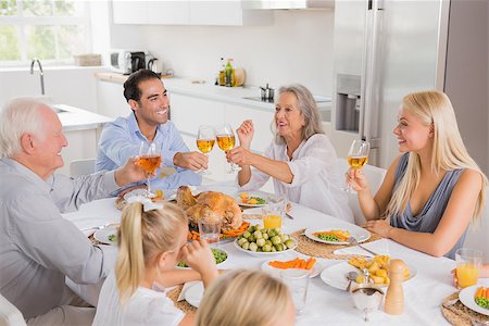 simsearch:400-06871557,k - Smiling adults raising their glasses at thanksgiving dinner Photographie de stock - Aubaine LD & Abonnement, Code: 400-06871625