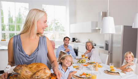 simsearch:400-06871557,k - Woman looking her family and holding a turkey Photographie de stock - Aubaine LD & Abonnement, Code: 400-06871630