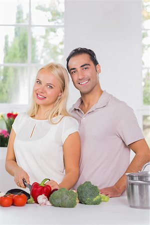 Smiling blonde woman cooking with her husband in the kitchen Stock Photo - Budget Royalty-Free & Subscription, Code: 400-06871643