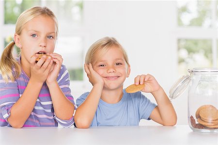 Brother and sister eating biscuits together in the kitchen Stock Photo - Budget Royalty-Free & Subscription, Code: 400-06871665