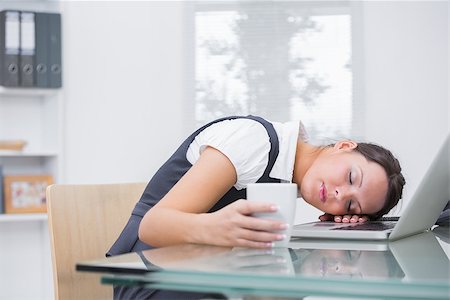 simsearch:614-00602959,k - Young business woman with coffee cup resting head on laptop at desk in office Photographie de stock - Aubaine LD & Abonnement, Code: 400-06871830