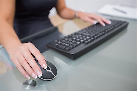 Midsection of woman using computer mouse and keyboard at office desk Stock Photo - Budget Royalty-Free & Subscription, Code: 400-06871833