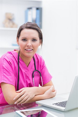 simsearch:400-04704005,k - Portrait of smiling young nurse with laptop at desk in clinic Stock Photo - Budget Royalty-Free & Subscription, Code: 400-06871930