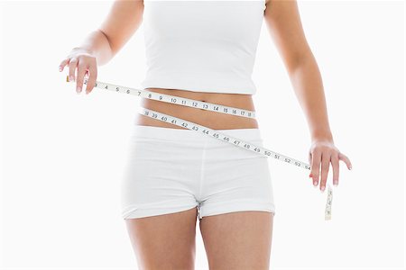 simsearch:400-07936547,k - Midsection of woman measuring waist over white background Foto de stock - Super Valor sin royalties y Suscripción, Código: 400-06871981