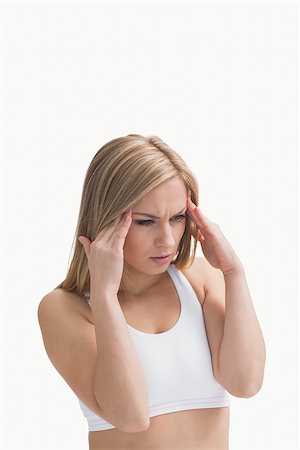 Young woman rubbing her temples over white background Stock Photo - Budget Royalty-Free & Subscription, Code: 400-06872058