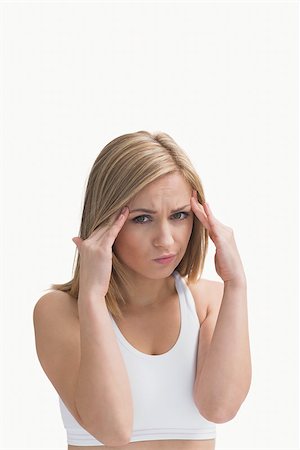 Portrait of young woman rubbing her temples over white background Stock Photo - Budget Royalty-Free & Subscription, Code: 400-06872059