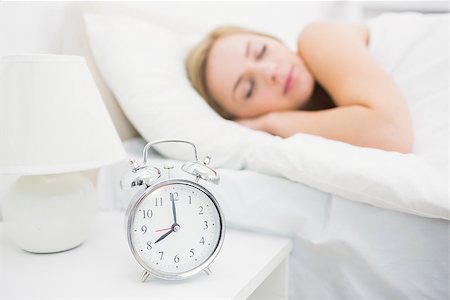 Young woman sleeping in bed with focus on alarm clock at home Stock Photo - Budget Royalty-Free & Subscription, Code: 400-06872175