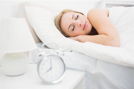 Alarm clock on table with focus on young woman sleeping in bed at home Stock Photo - Budget Royalty-Free & Subscription, Code: 400-06872176