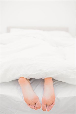 Womans feet sticking out of blanket on bed at home Stock Photo - Budget Royalty-Free & Subscription, Code: 400-06872194