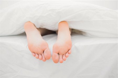 Womans feet sticking out of blanket on bed at home Stock Photo - Budget Royalty-Free & Subscription, Code: 400-06872195