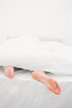 Womans feet sticking out of blanket on bed at home Stock Photo - Budget Royalty-Free & Subscription, Code: 400-06872193