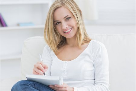 simsearch:400-06872352,k - Portrait of happy young woman with notepad and pen on couch at home Foto de stock - Royalty-Free Super Valor e Assinatura, Número: 400-06872406