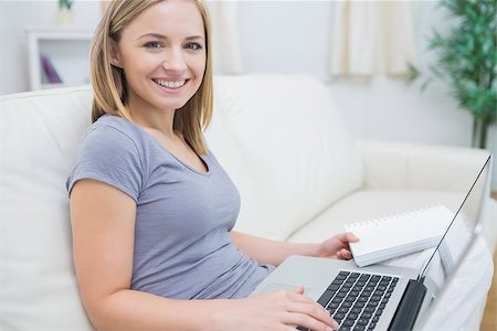 simsearch:400-06872352,k - Portrait of casual young woman with laptop and book in living room at home Foto de stock - Royalty-Free Super Valor e Assinatura, Número: 400-06872480