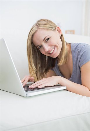 simsearch:400-06872352,k - Portrait of casual young woman lying on couch and using laptop at home Foto de stock - Royalty-Free Super Valor e Assinatura, Número: 400-06872494