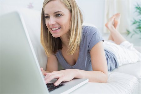 simsearch:400-06872352,k - Casual young woman lying on couch and using laptop at home Foto de stock - Royalty-Free Super Valor e Assinatura, Número: 400-06872497