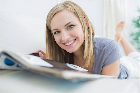 simsearch:400-06872352,k - Portrait of casual young woman with magazine lying on couch at home Foto de stock - Royalty-Free Super Valor e Assinatura, Número: 400-06872501