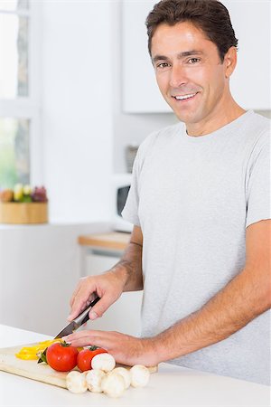 simsearch:400-06891385,k - Smiling man preparing vegetables in the kitchen Stock Photo - Budget Royalty-Free & Subscription, Code: 400-06872674