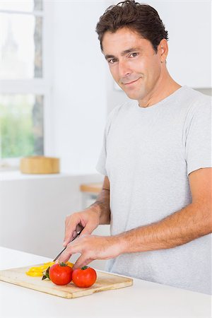 simsearch:400-06891385,k - Smiling man slicing peppers in kitchen Stock Photo - Budget Royalty-Free & Subscription, Code: 400-06872672