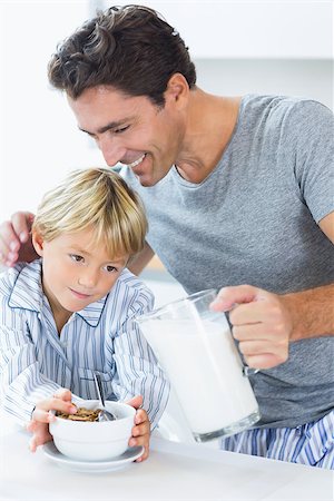 simsearch:400-06871178,k - Smiling father pouring milk for sons cereal at breakfast Stock Photo - Budget Royalty-Free & Subscription, Code: 400-06872768