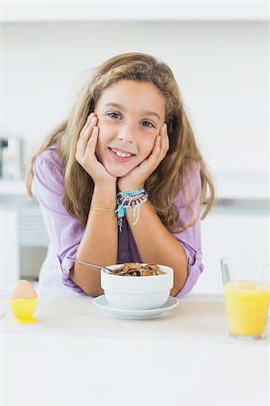 simsearch:400-06871178,k - Happy girl at breakfast in the kitchen Stock Photo - Budget Royalty-Free & Subscription, Code: 400-06872779