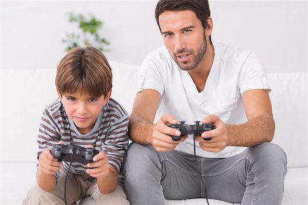sofa two boys video game - Father and son playing video games on the couch Stock Photo - Budget Royalty-Free & Subscription, Code: 400-06872917