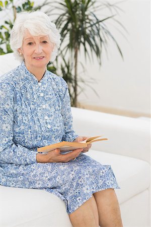 simsearch:400-04026722,k - Elderly woman reading a old novel and looking at camera on a sofa Stock Photo - Budget Royalty-Free & Subscription, Code: 400-06873102