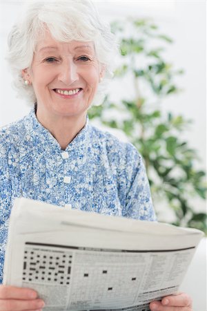 simsearch:693-06019332,k - Elderly smiling woman reading newspapers on a sofa Stock Photo - Budget Royalty-Free & Subscription, Code: 400-06873120