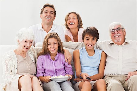 senior man watching tv family - Multi generation family on couch watching tv and smiling Stock Photo - Budget Royalty-Free & Subscription, Code: 400-06873413