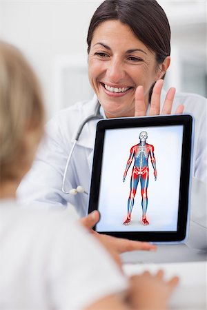 Smiling doctor showing a tablet computer to a child in hospital ward Stock Photo - Budget Royalty-Free & Subscription, Code: 400-06873500