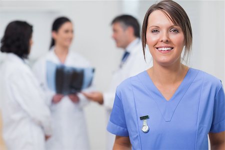 doctor team portrait - Nurse smiling with her team behind her holding an xray Stock Photo - Budget Royalty-Free & Subscription, Code: 400-06873874